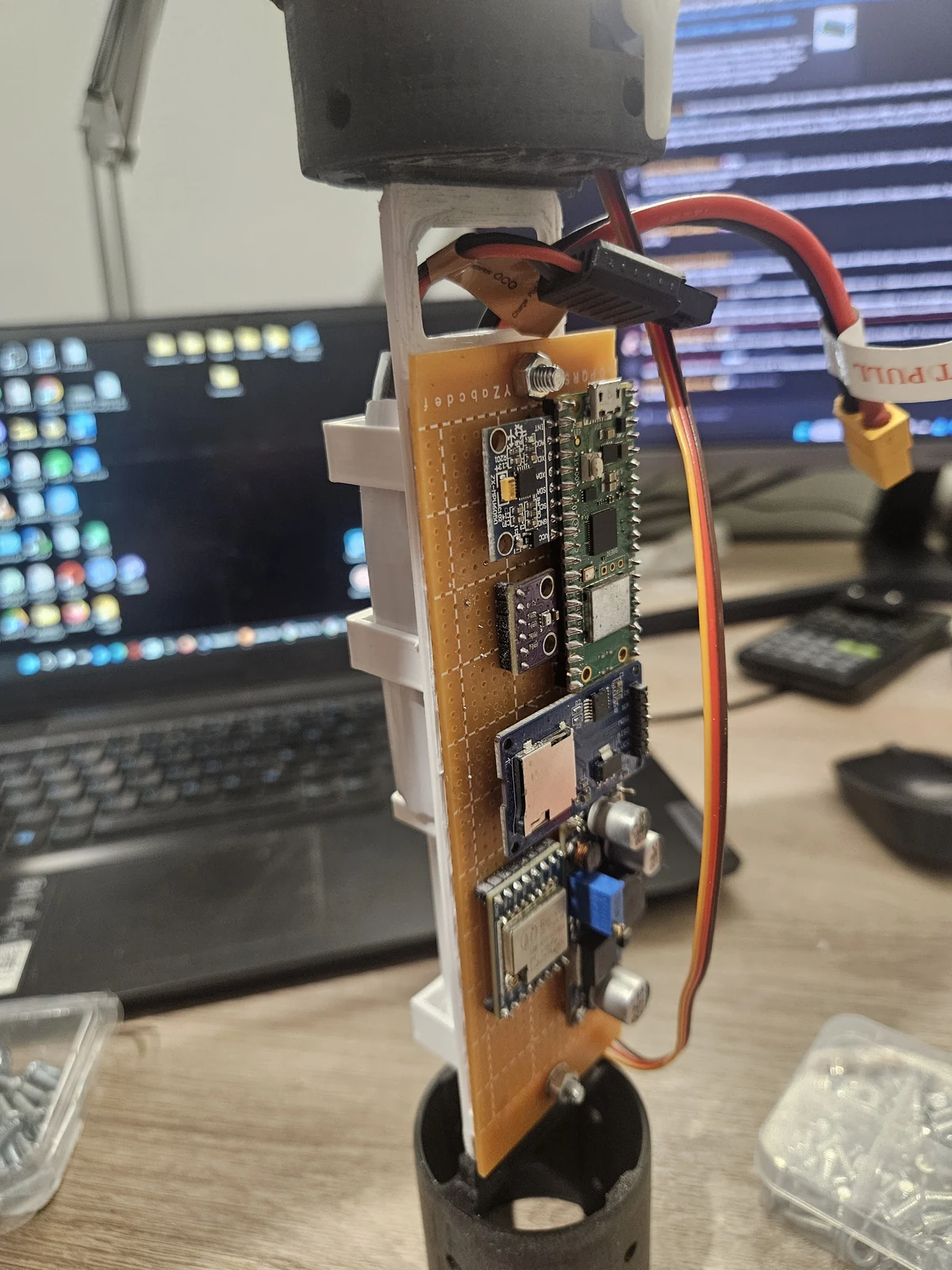 An assembled electronics and sensor board on a mount in the workshop